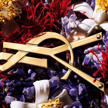 Gold YSL chain on top of ingredients Lavender, Orange Blossom, and Saffron Accord